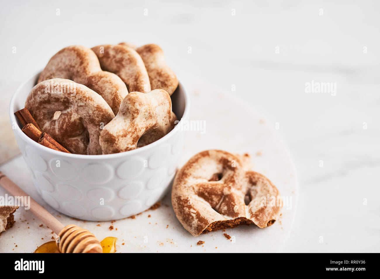 Chtristmas tradizionali biscotti di panpepato fatte di zenzero, miele e cannella con ghiaccio nel recipiente bianco su bianco piastra servig su marmo bianco backgro Foto Stock