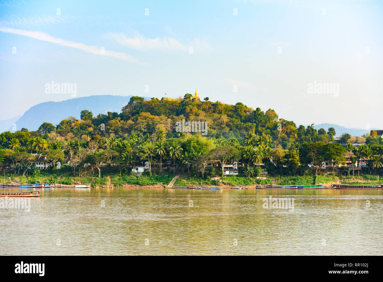Splendida vista della splendida Luang Prabang città con il fiume Mekong che scorre in primo piano e il Phou Si Mountain in background. Foto Stock