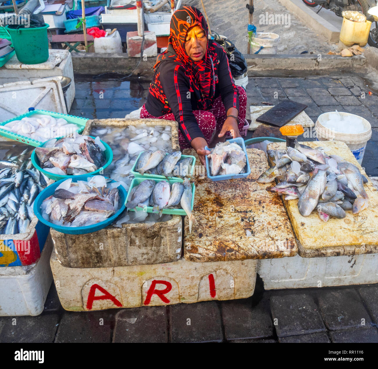 Femmina pescivendolo la vendita di pesce fresco al Kedonganan Mercato del Pesce, la baia di Jimbaran Bali Indonesia. Foto Stock