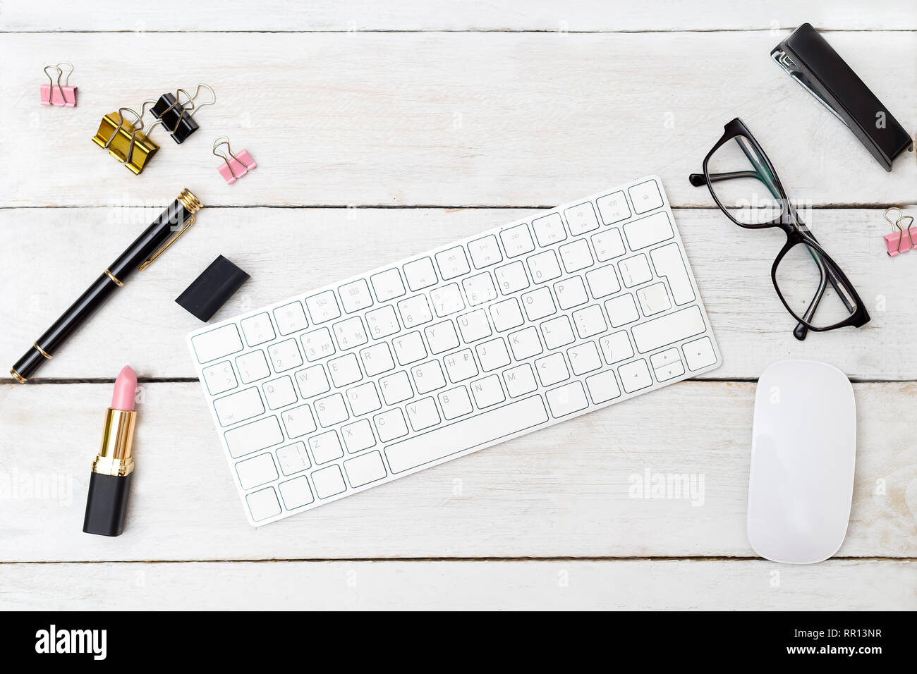 Stile scrivania femminile con il rossetto e tastiera. Flatlay Foto Stock