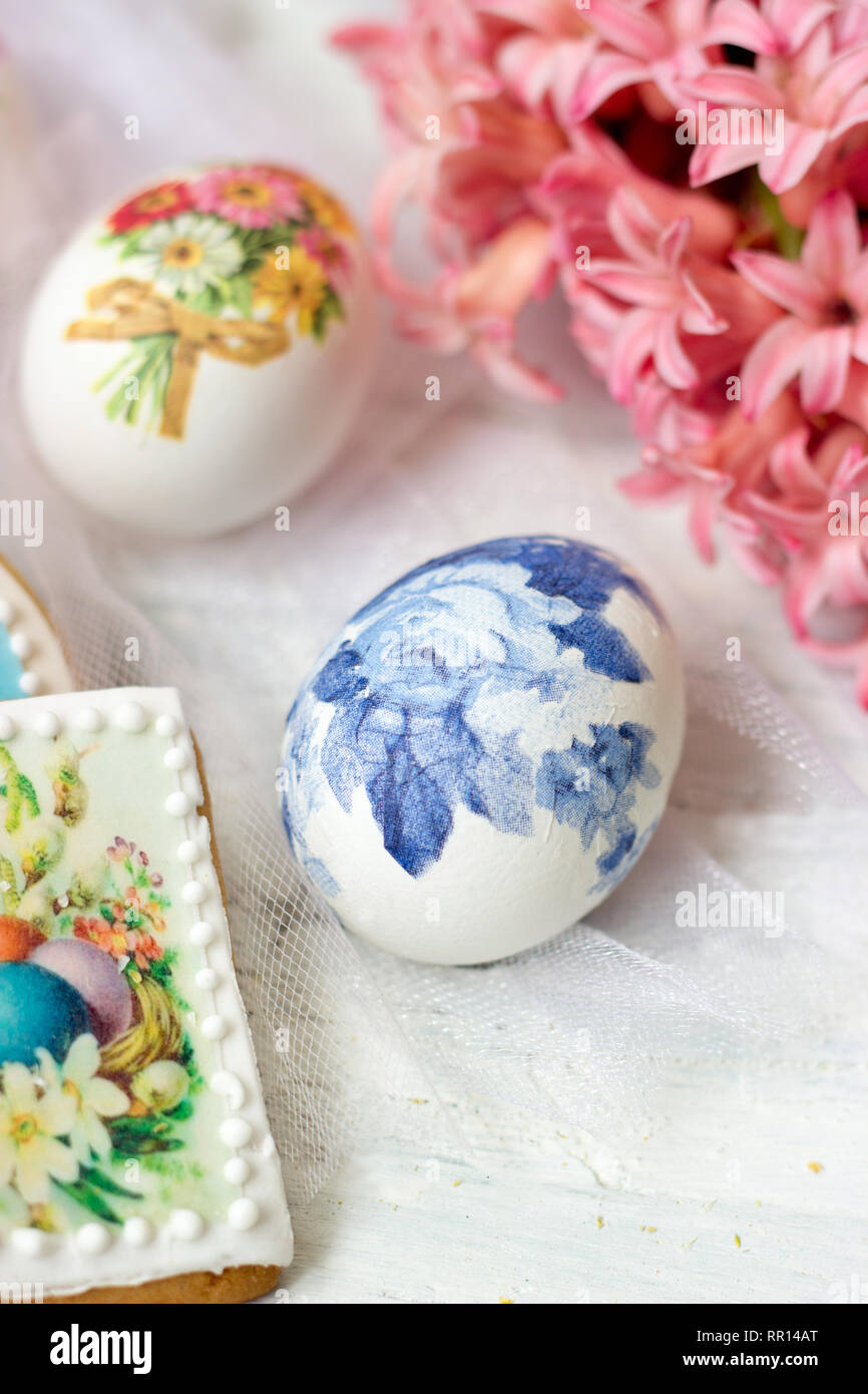 Decorate le uova di Pasqua e fiori su tulle bianco sullo sfondo; tecnica decoupage Foto Stock