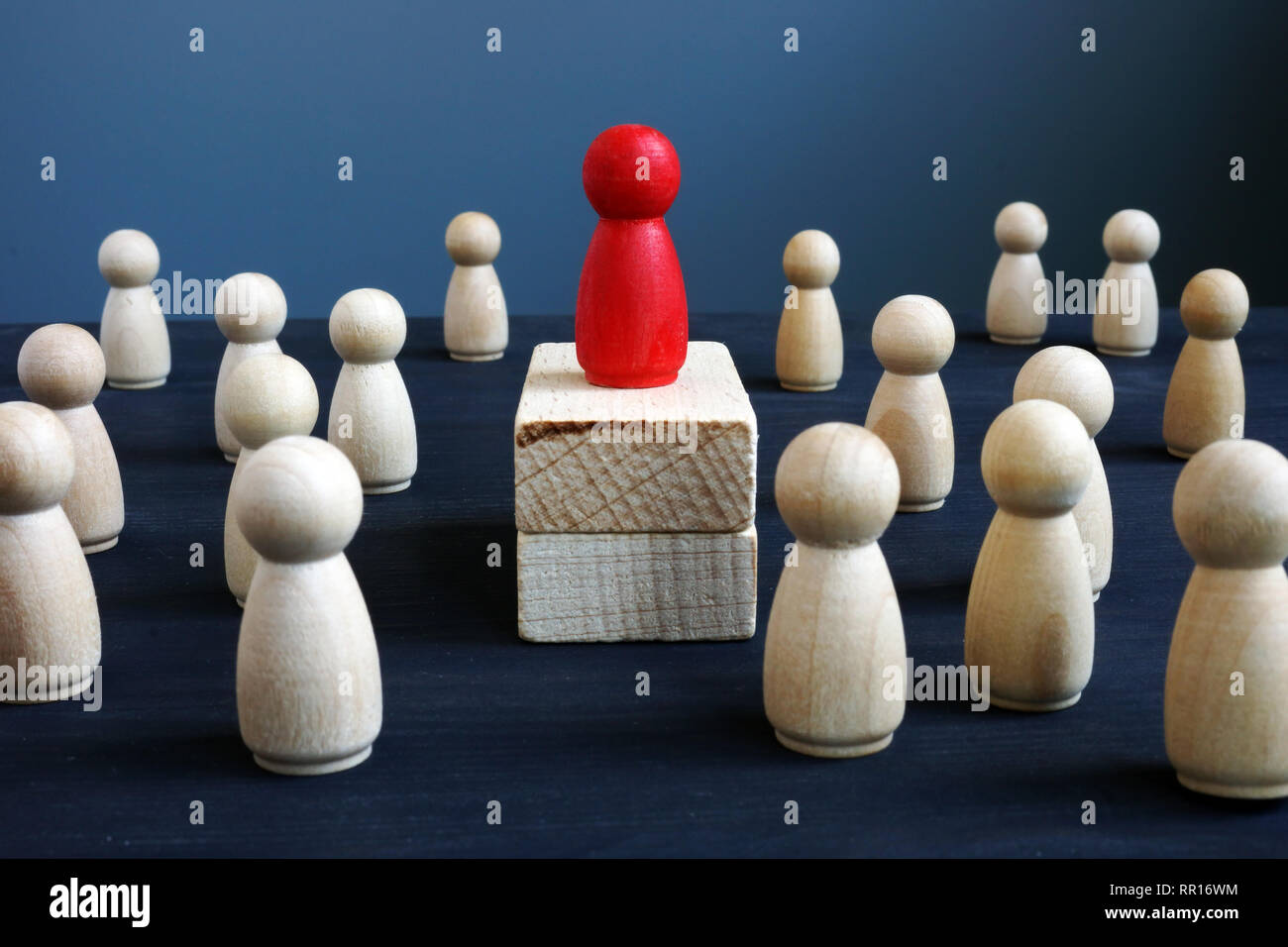 La posizione dominante, la potenza e il concetto di leadership. Rosso statuetta in legno su blocchi. Foto Stock