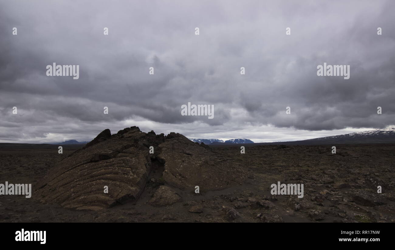 Una fessura su un campo di lava lungo il backcountry strada di montagna F35 nelle highlands interiore dell'Islanda con cielo nuvoloso. Foto Stock