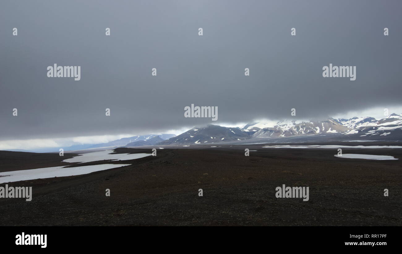 Una vista da backcountry strada di montagna F35 nelle highlands interiore dell'Islanda verso il ghiacciaio Hofsjokull con molto basse nuvole. Foto Stock