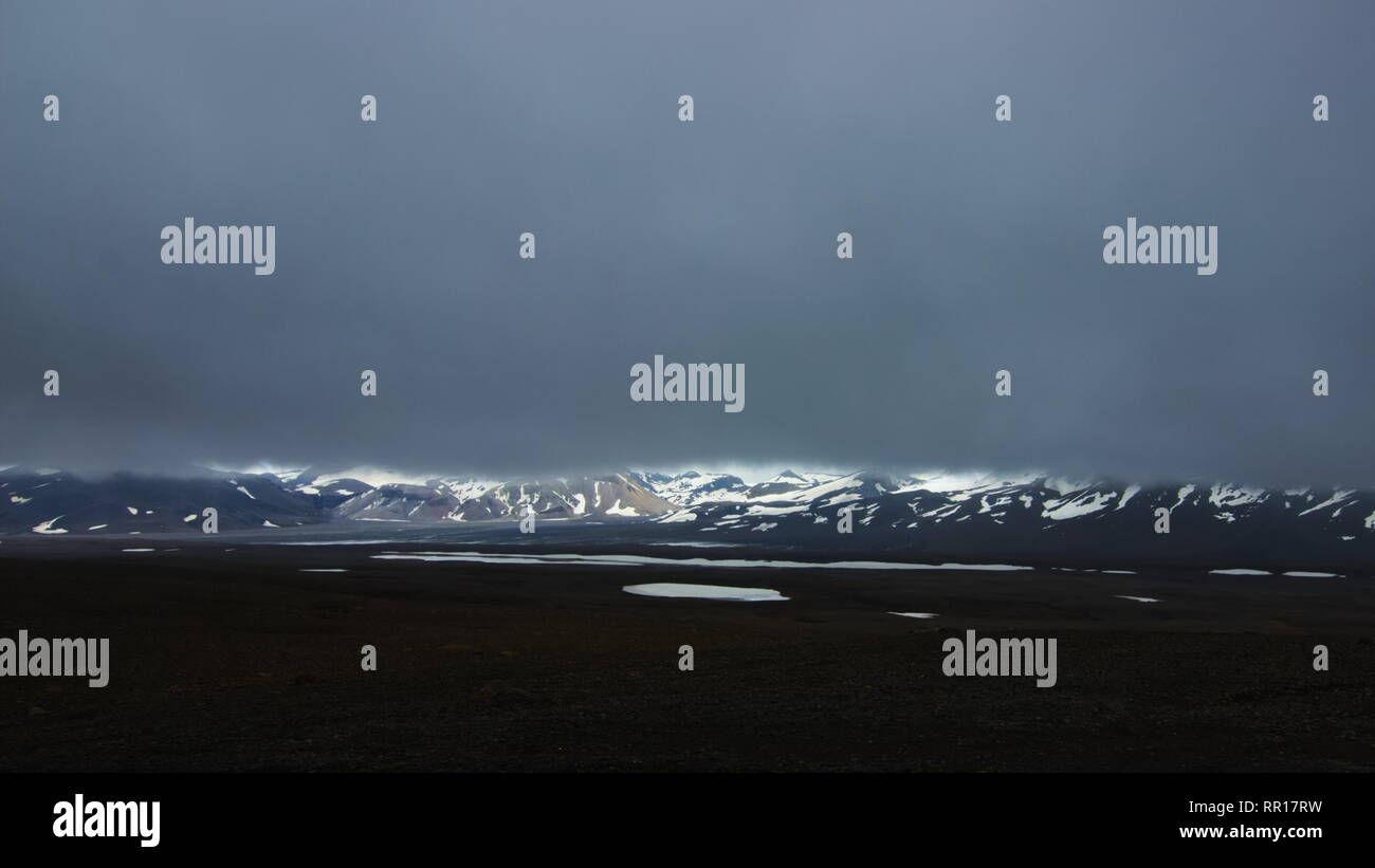 Una vista da backcountry strada di montagna F35 nelle highlands interiore dell'Islanda verso il ghiacciaio Hofsjokull con molto basse nuvole. Foto Stock