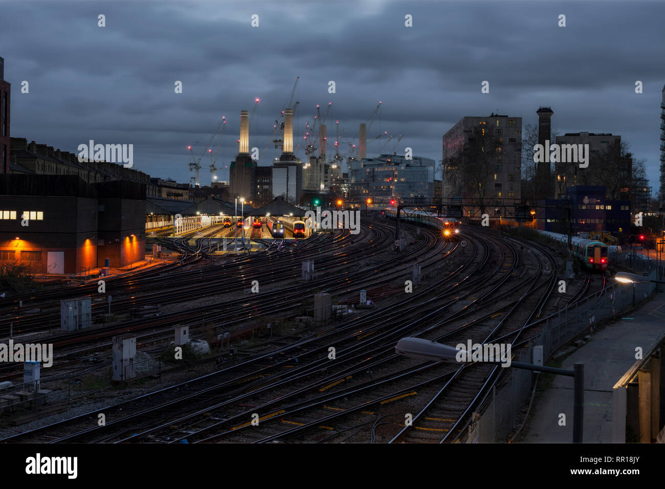 Vista della ferrovia a Grosvenor Road Depot, Ebury Bridge, London Victoria con Battersea Power Station dietro come sud arriva in treno Foto Stock