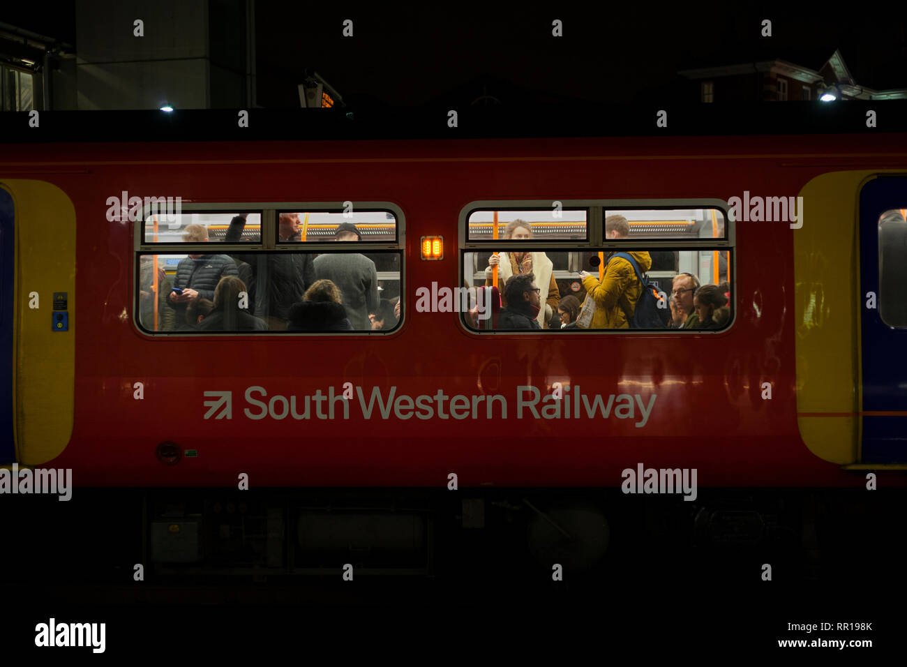 Rail Pendolari su un affollato sud occidentale del treno Ferrovie voce lontano da Londra a Clapham Junction in serata Rush Hour Foto Stock