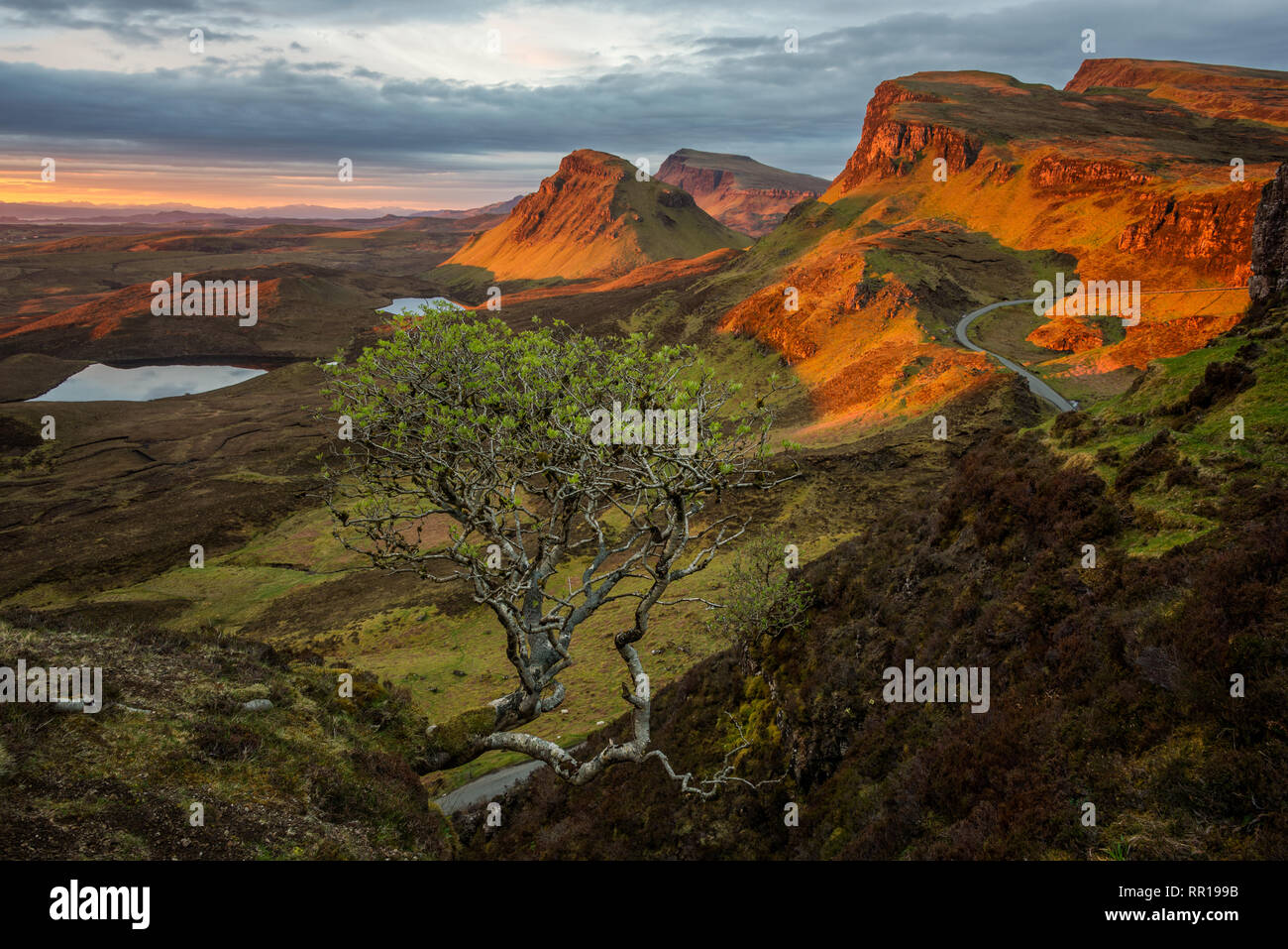 Primi raggi di sole brilla di una luce sul Quiraing montagne a sunrise nel paesaggio di Trotternish Ridge sull isola di Skye in Scozia nel Regno Unito. Foto Stock