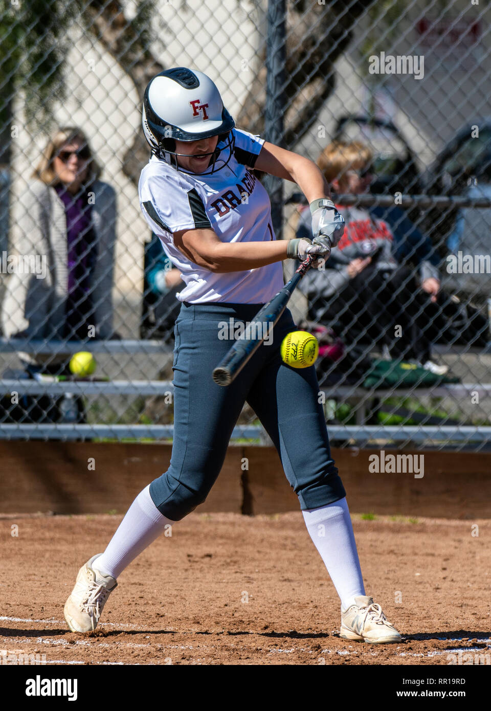 Softball player in bianco uniforme ha bat in perfetta posizione per colpire sweet spot durante il gioco tra la tecnologia Foothill High School e Pioneer Valley o Foto Stock