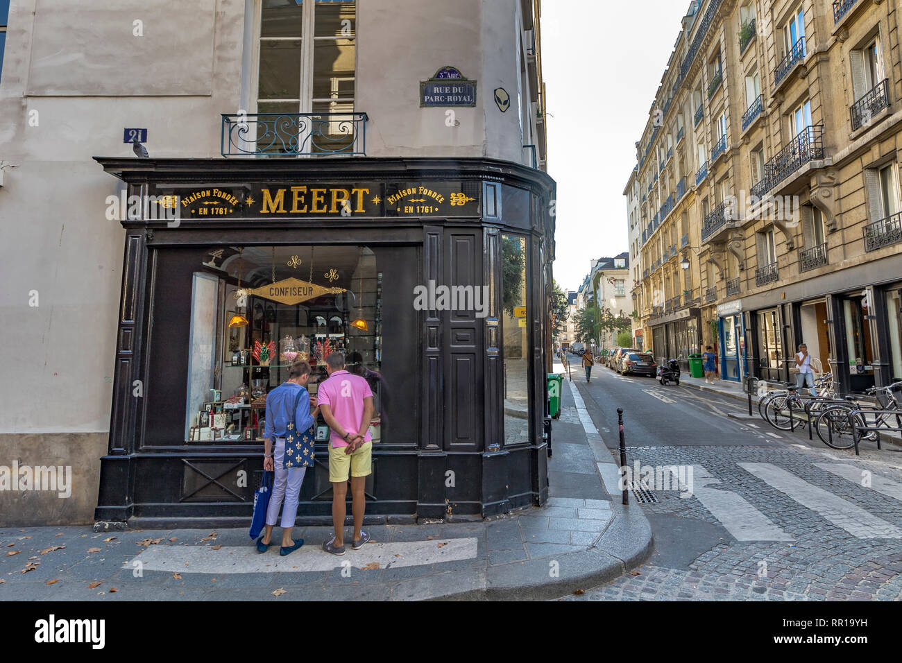 Due persone che guardano la finestra di visualizzazione in Meert , un negozio di cioccolato di qualità, biscotti e torte nel quartiere alla moda di Marais di Parigi Foto Stock