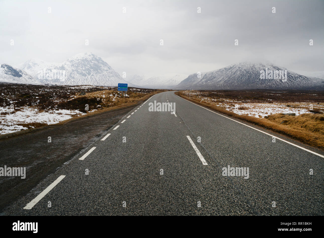 Un vuoto del tratto di strada che conduce da Rannoch Moor in una parzialmente coperta di neve Glencoe nelle Highlands scozzesi, Scotland, Regno Unito. Foto Stock