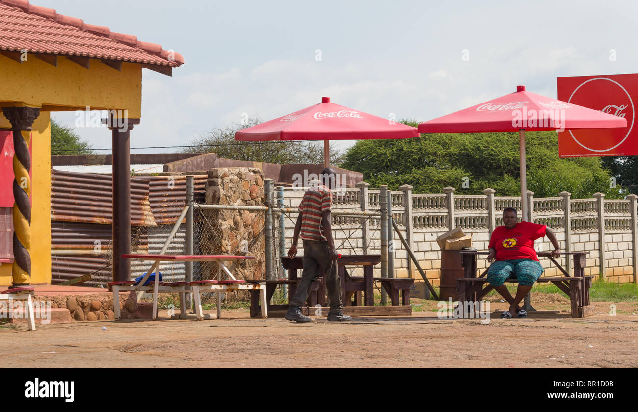 Nero donna africana con un rosso EFF partito politico t-shirt su seduti all'aperto in corrispondenza di un banco in ombra nord ovest della provincia, Sud Africa Foto Stock Nero donna africana con un rosso EFF partito politico t-shirt su seduti all'aperto in corrispondenza di un banco in ombra nord ovest della provincia, Sud Africa Foto Stock