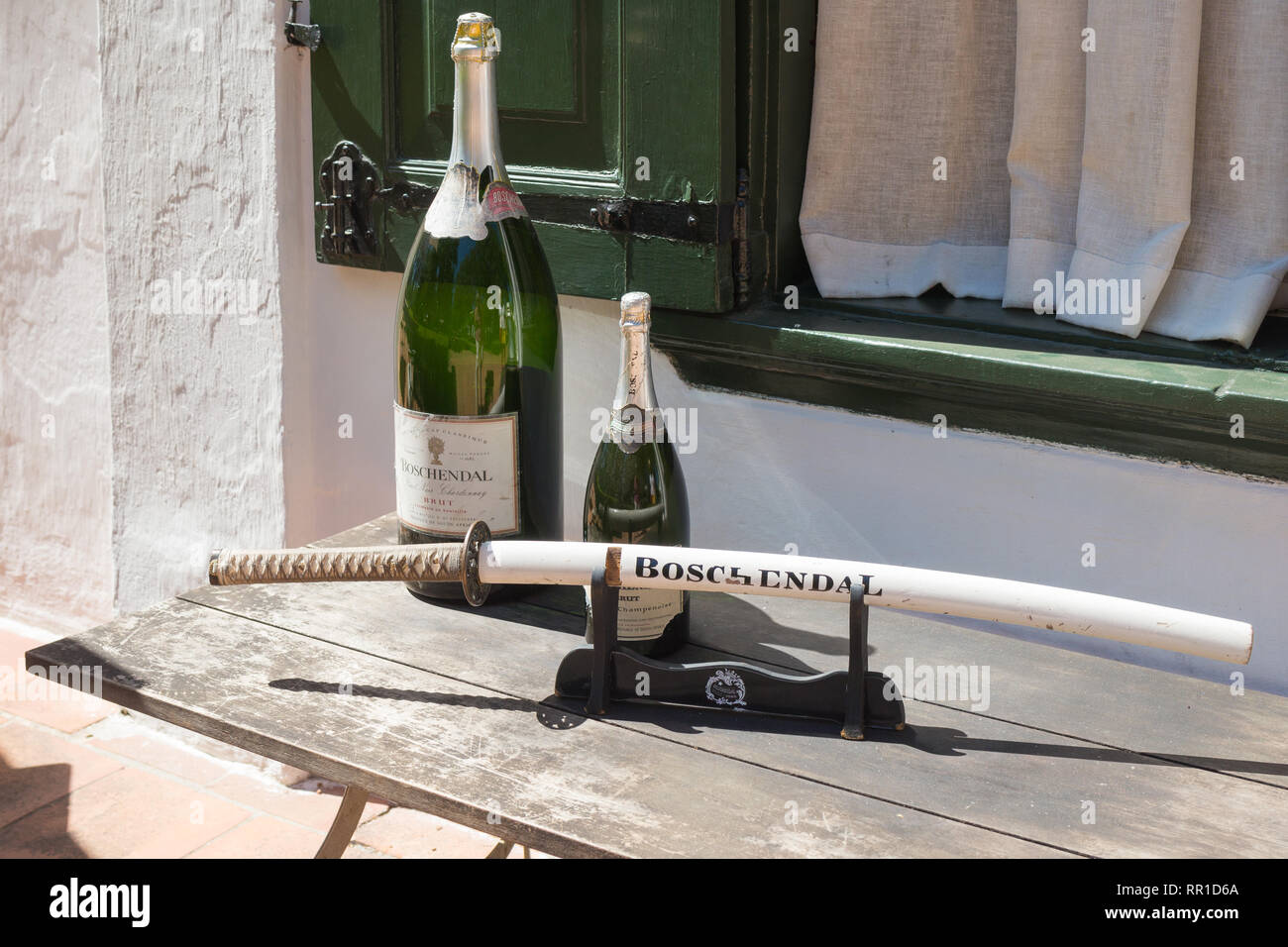 Boschendal cantina bottiglie di vino spumante o Magnum con una spada per sabrage su un tavolo esterno alla Manor House Cape Winelands, Sud Africa Foto Stock