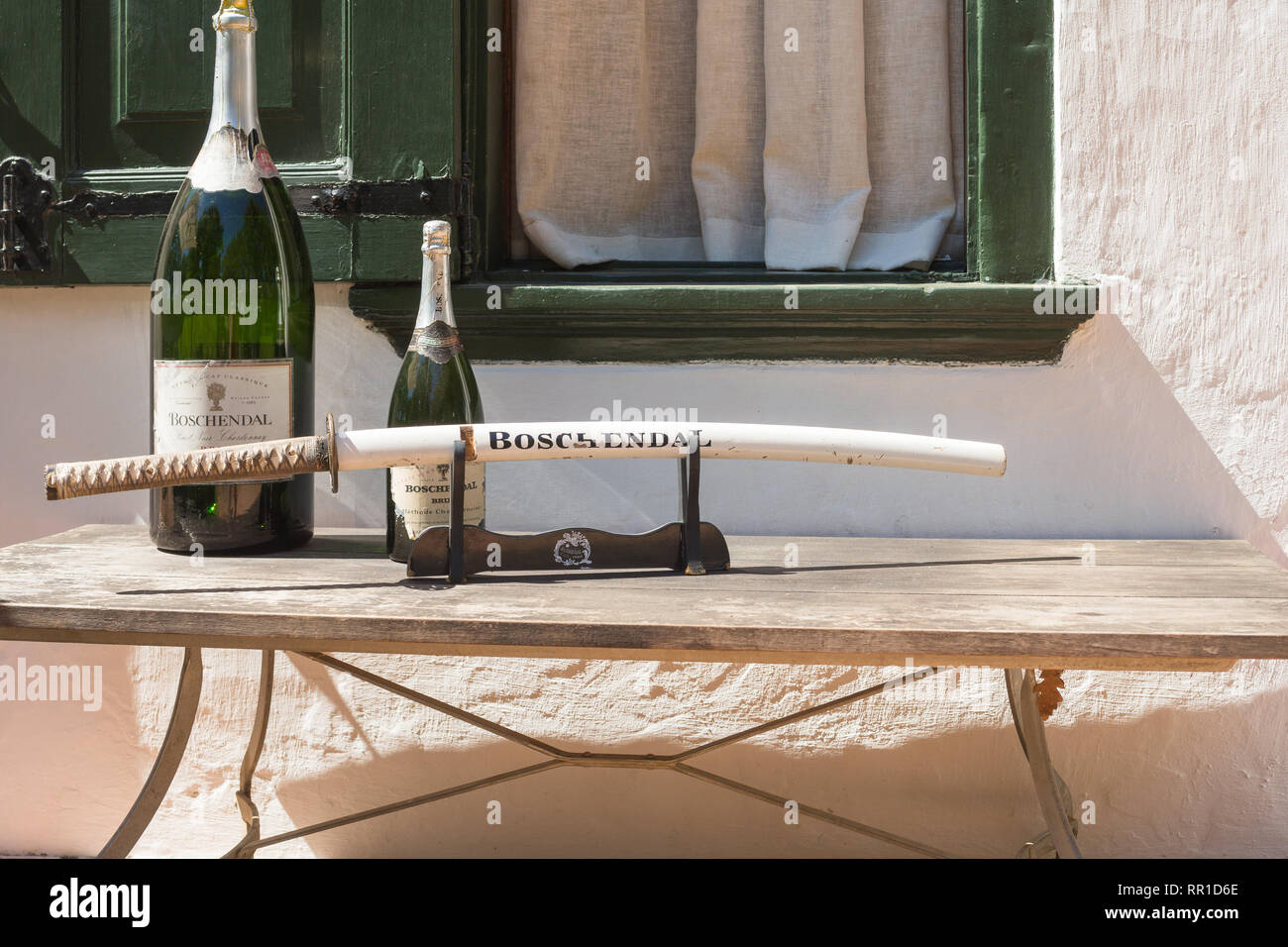 Boschendal cantina bottiglie di vino spumante o Magnum con una spada per sabrage su un tavolo esterno alla Manor House Cape Winelands, Sud Africa Foto Stock