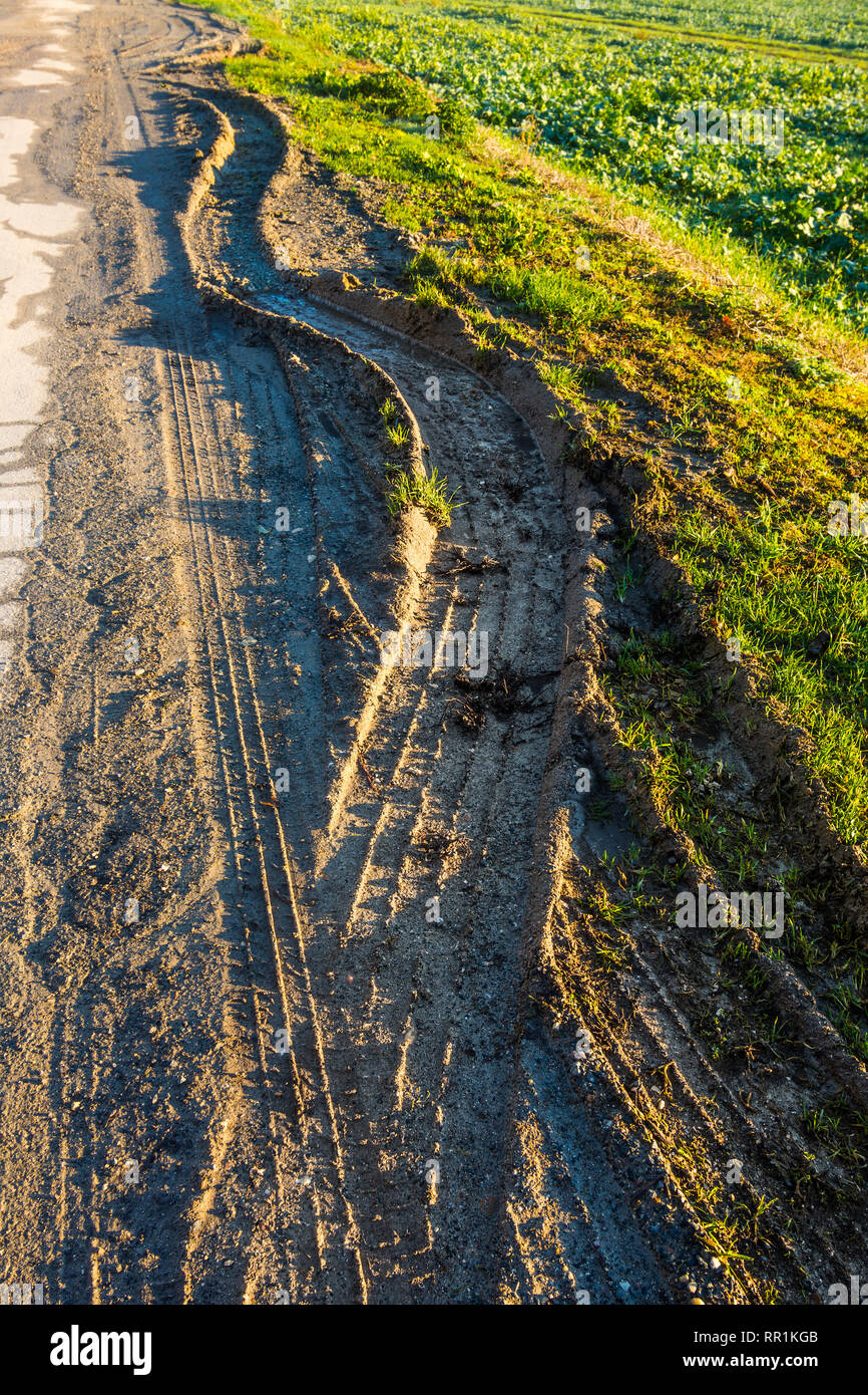 Profonde tracce di pneumatici di veicoli pesanti su terreni fangosi orlo della strada, Francia. Foto Stock