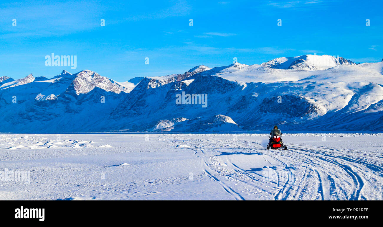 Snowmobiler guidare oltre il Cumberland Sound per arrivare alla loro pesca shack in cerca di rombo. Foto Stock