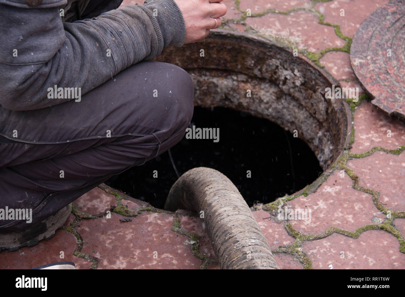 L'uomo il Pompaggio acque reflue dal foro di scarico Foto Stock