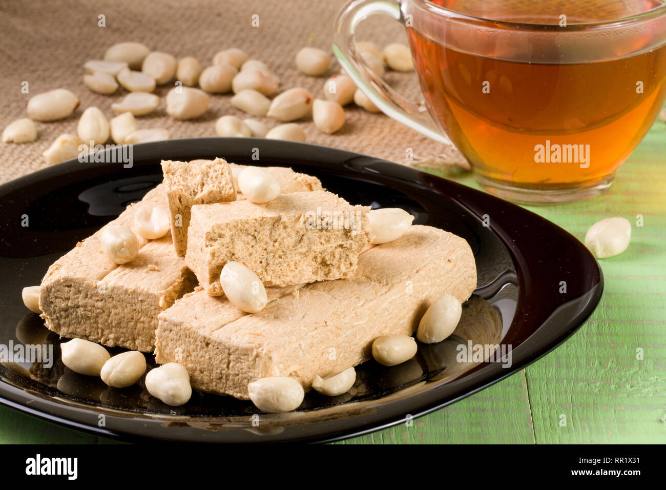 Peanut halva nella piastra su un verde sullo sfondo di legno Foto Stock