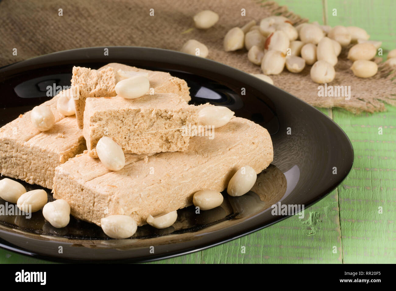 Peanut halva nella piastra su un verde sullo sfondo di legno Foto Stock