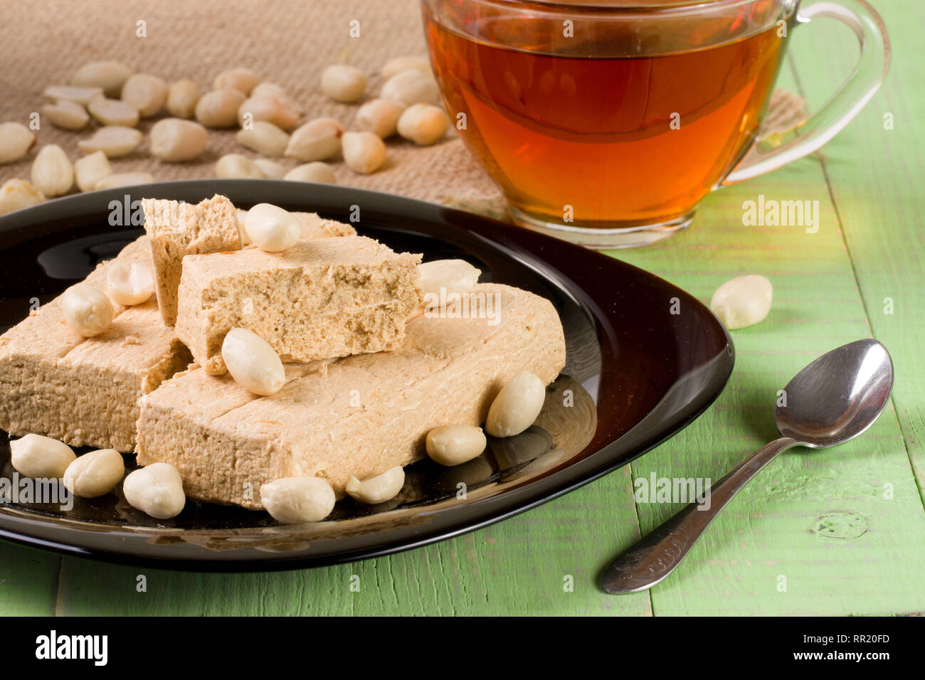 Peanut halva nella piastra su un verde sullo sfondo di legno Foto Stock