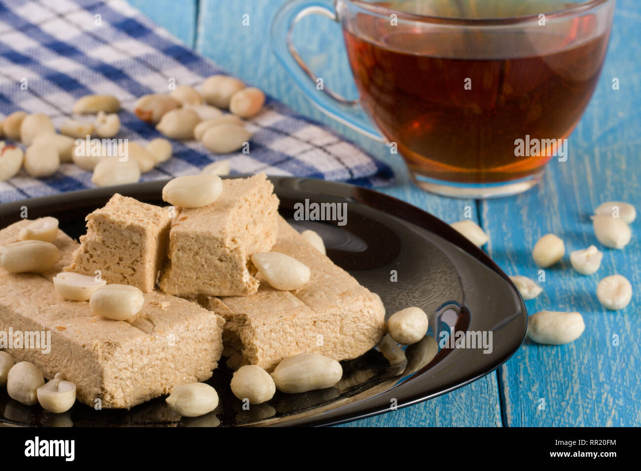 Peanut halva nella piastra su un blu sullo sfondo di legno Foto Stock