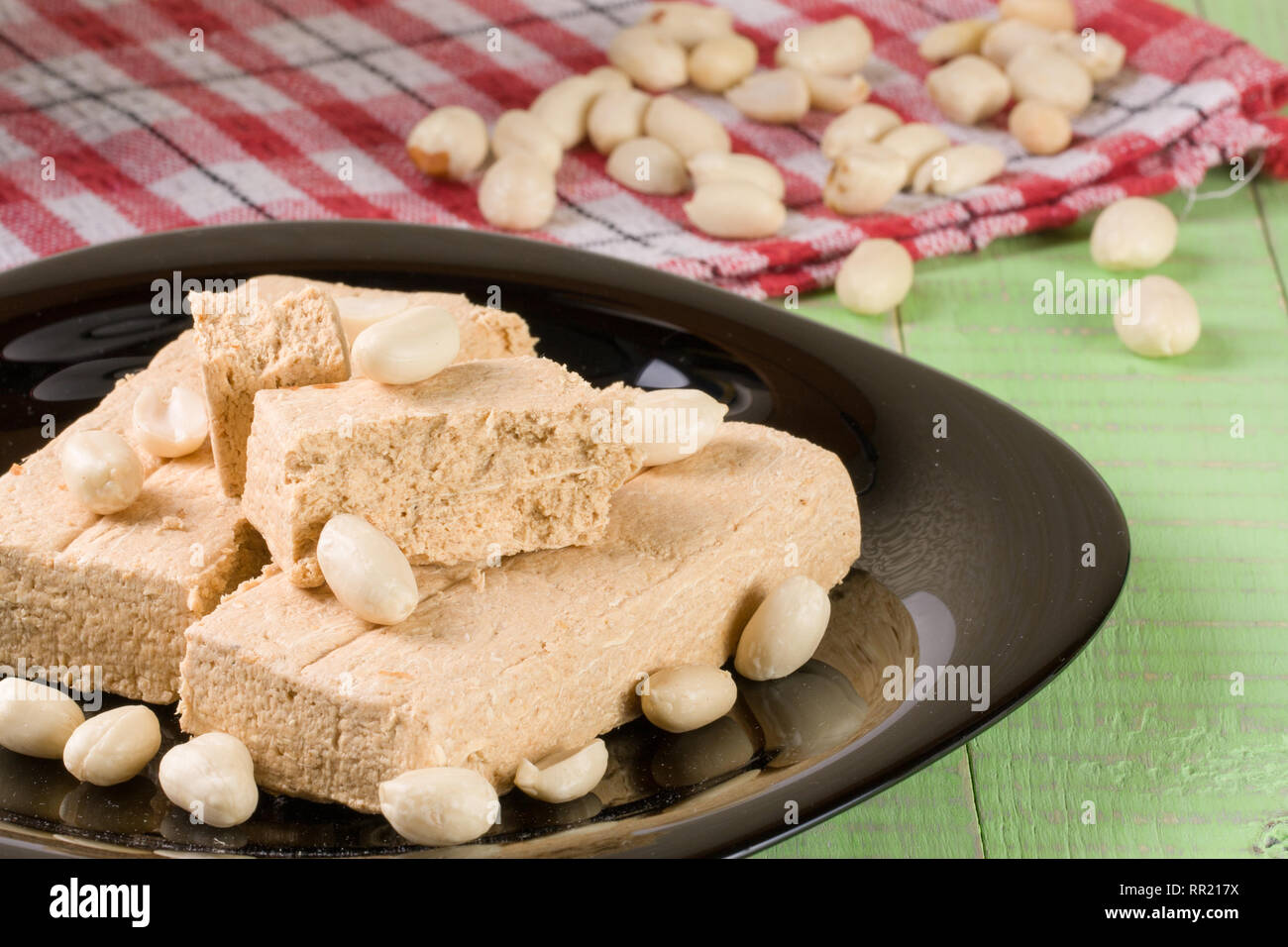 Peanut halva nella piastra su un verde sullo sfondo di legno Foto Stock