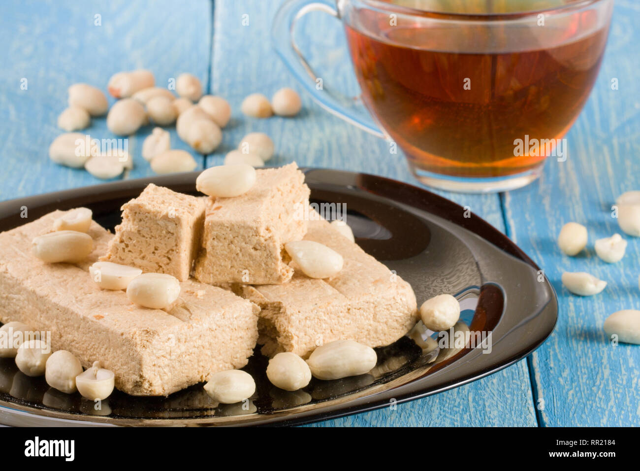 Peanut halva nella piastra su un blu sullo sfondo di legno Foto Stock