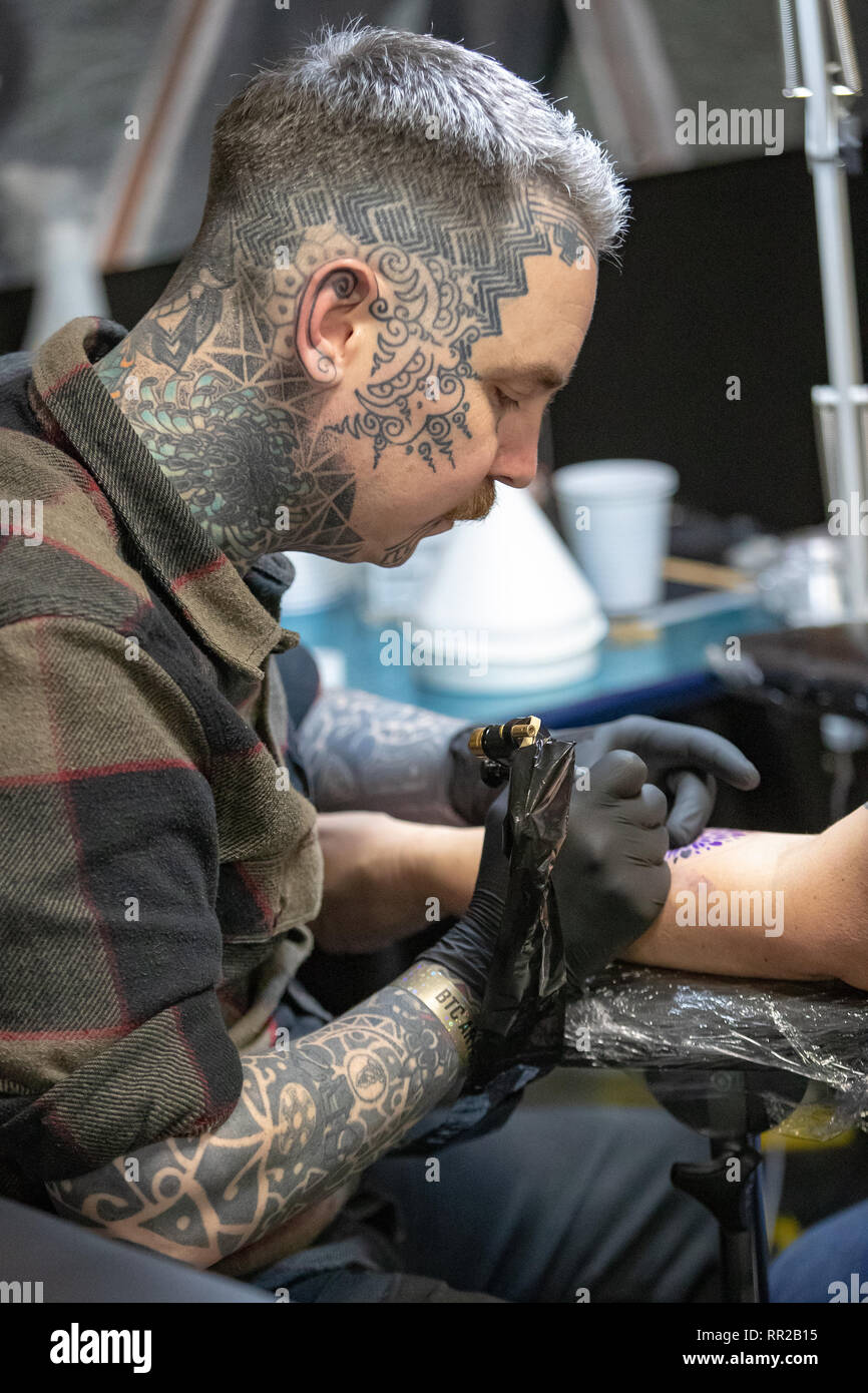 Brighton, Regno Unito. Il 23 febbraio, 2019. Tatuaggio artista lavora su un client in un dodicesimo annuale di Brighton Tattoo Convention presso il Centro di Brighton, Inghilterra. Credito: Jason Richardson/Alamy Live News Foto Stock