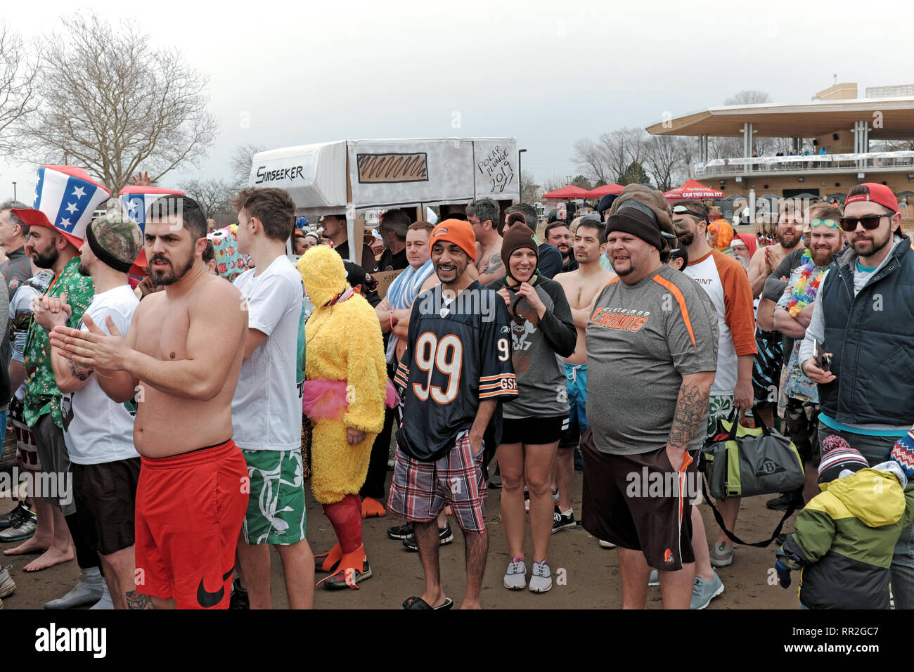 Cleveland, Ohio, USA. Il 23 febbraio, 2019. I partecipanti nel 2019 Cleveland tuffo polare al beneficio le Olimpiadi Speciali brave inverno aria fredda prima di prendere il tuffo nel ghiaccio-riempito le acque del Lago Erie. Questo evento annuale attira i partecipanti e spettatori di Cleveland Metroparks Edgewater Park sulle rive del Lago Erie per un divertente evento invernale. Credito: Mark Kanning/Alamy Live News. Foto Stock