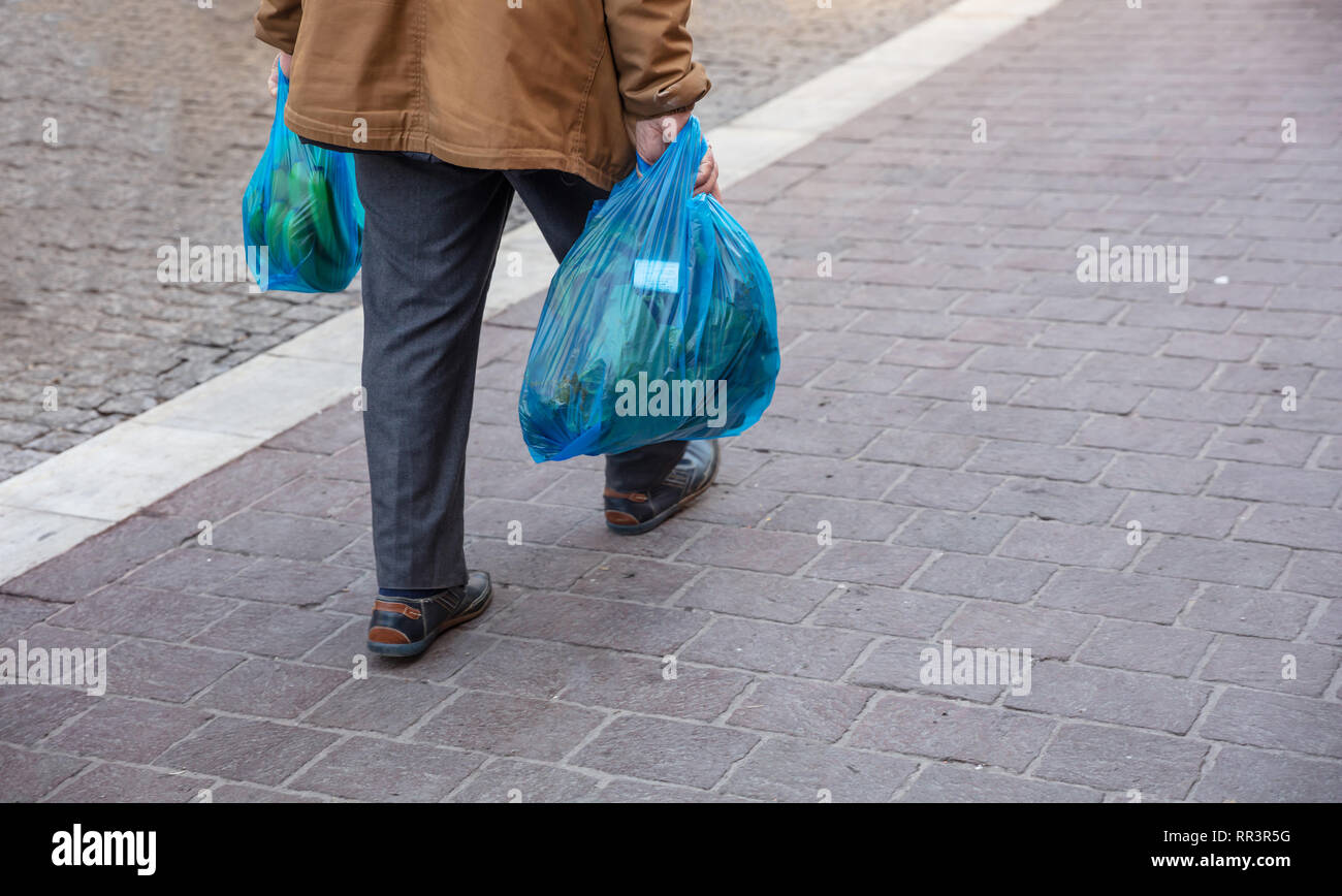 Il sacchetto in plastica utilizzare. Uomo Blu hoding sacchetti di plastica. Vista ingrandita, spazio di copia Foto Stock