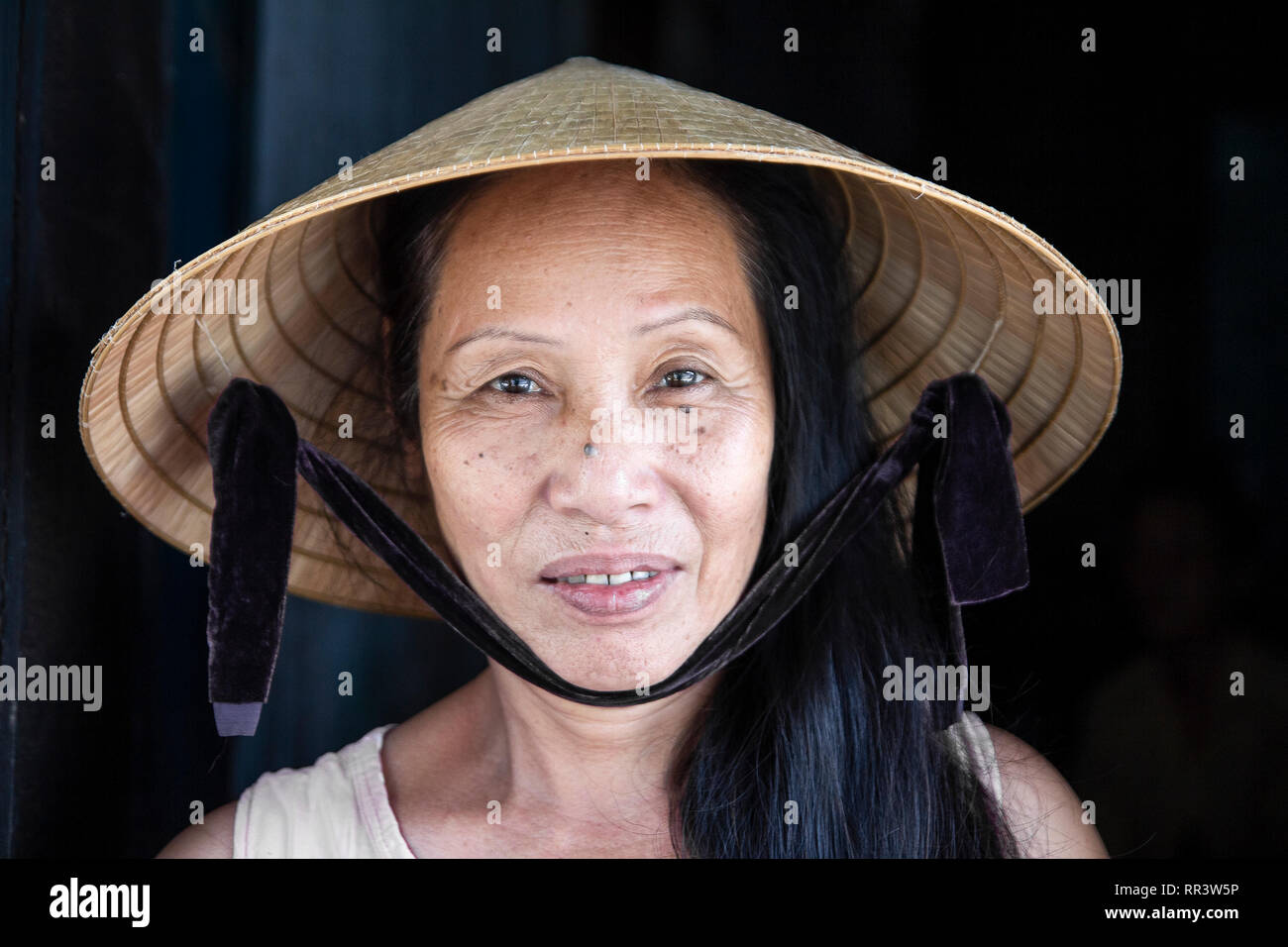Primo piano volto ritratto del vietnam donna che indossa cappello conico Foto Stock