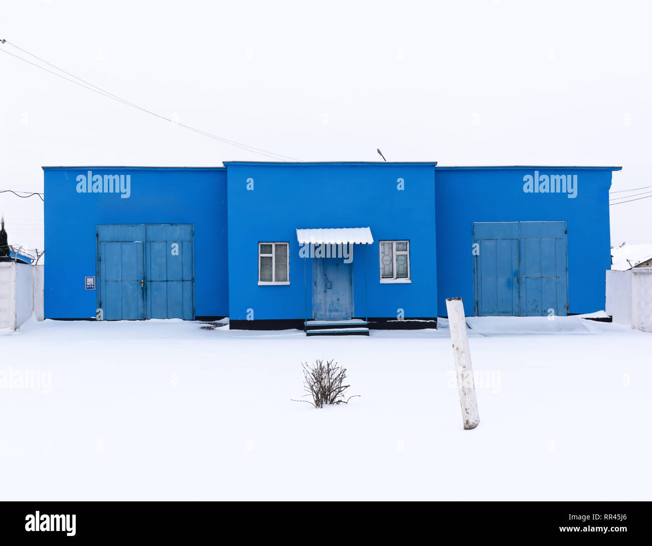 Edificio blu sulla strada innevata. Post architettura sovietica Foto Stock