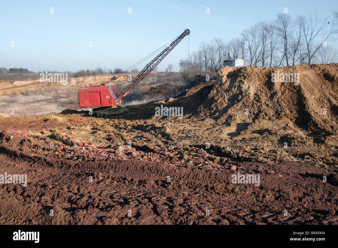 Escavatore in red cava di argilla. Background Industriale Foto Stock