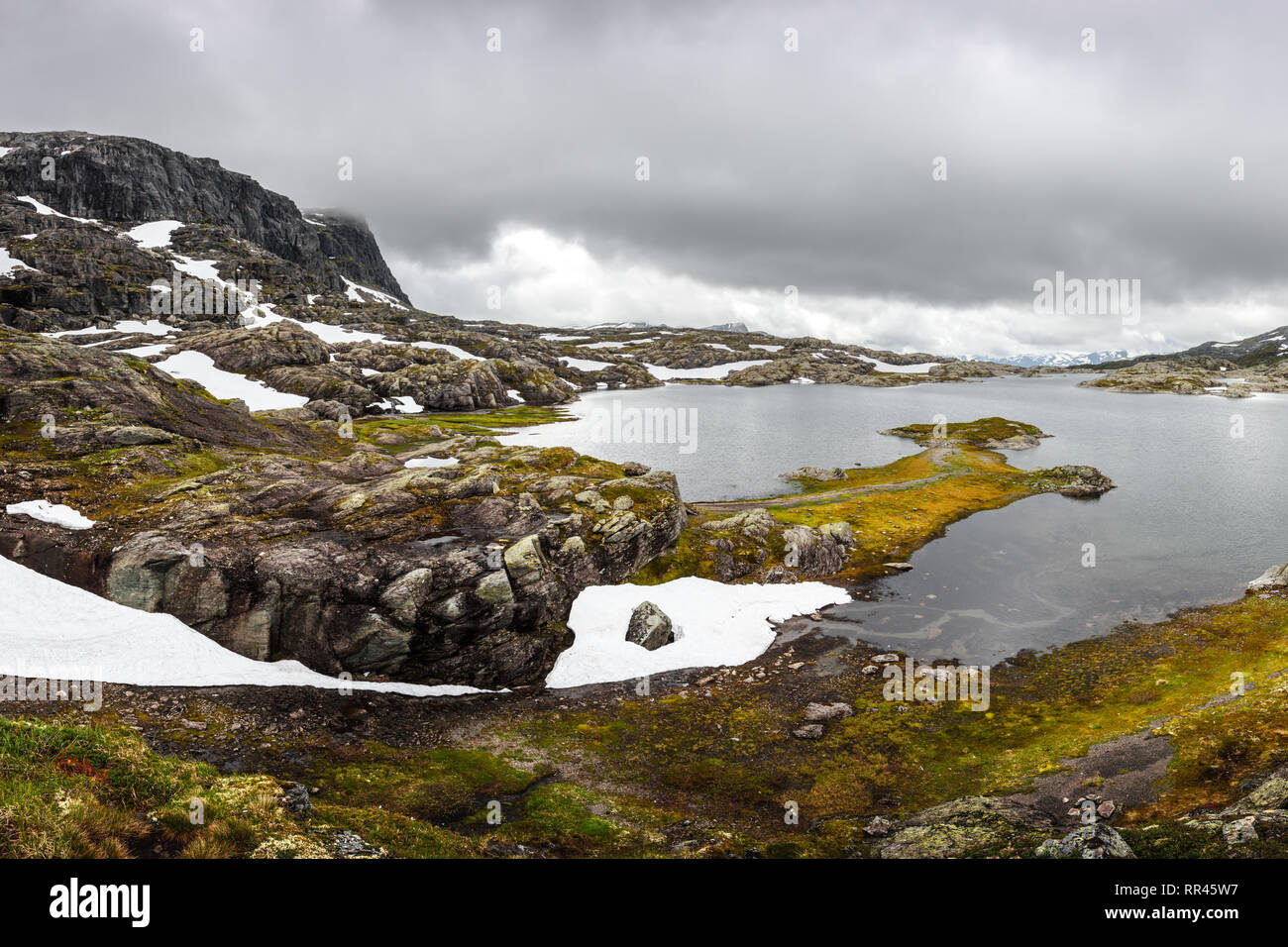 Tipico paesaggio norvegese con montagne innevate e chiaro lago vicino il Trolltunga rock - più spettacolare e famosa scenic cliff in Norvegia Foto Stock