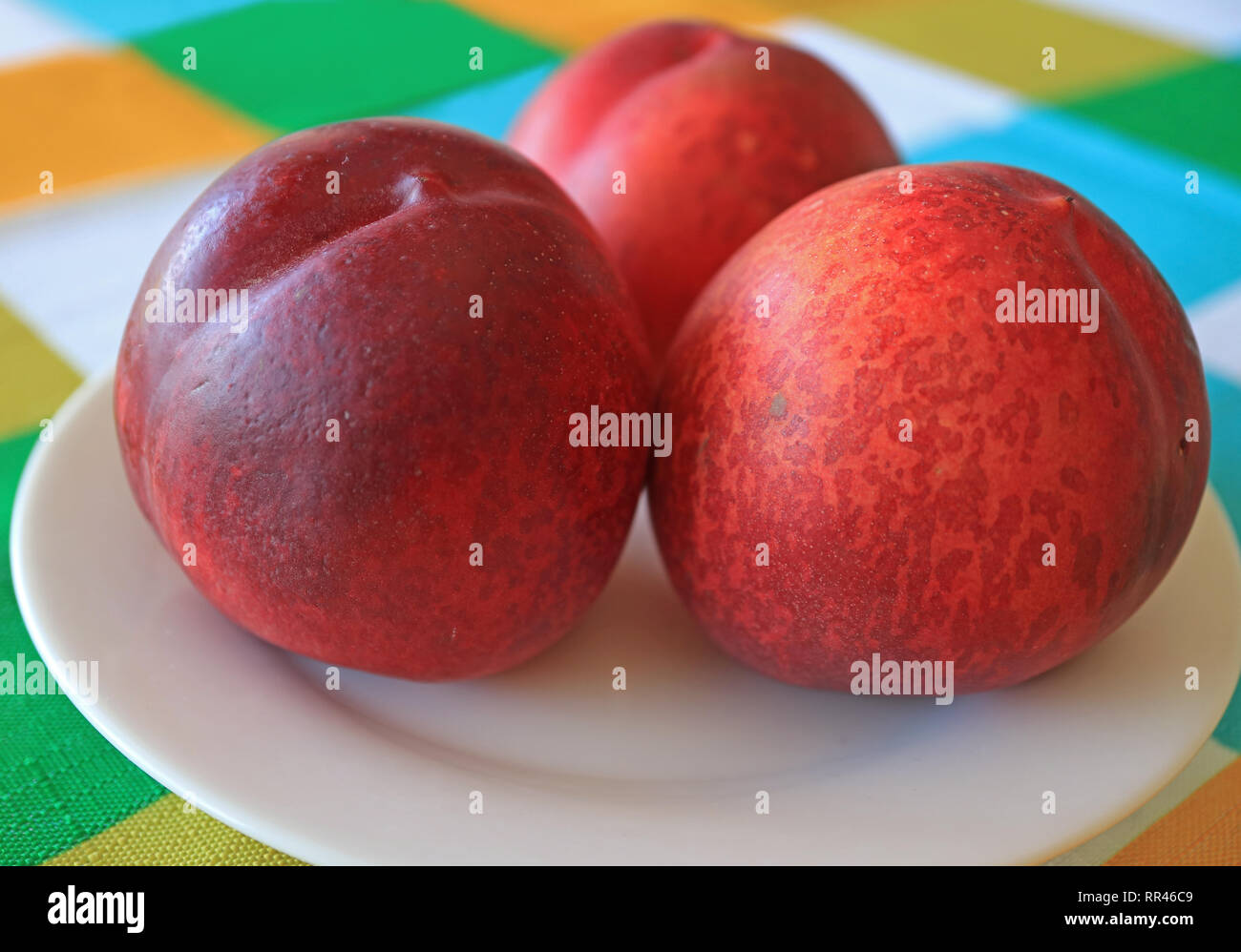 Chiudere fino a tre fresche e mature le pesche noci la frutta intera servita su piastra bianca Foto Stock
