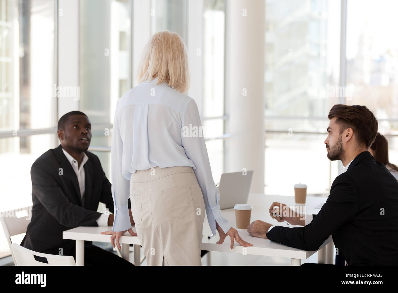 Seri lavoratori seduto alla scrivania di ascolto mentor maturo Foto Stock