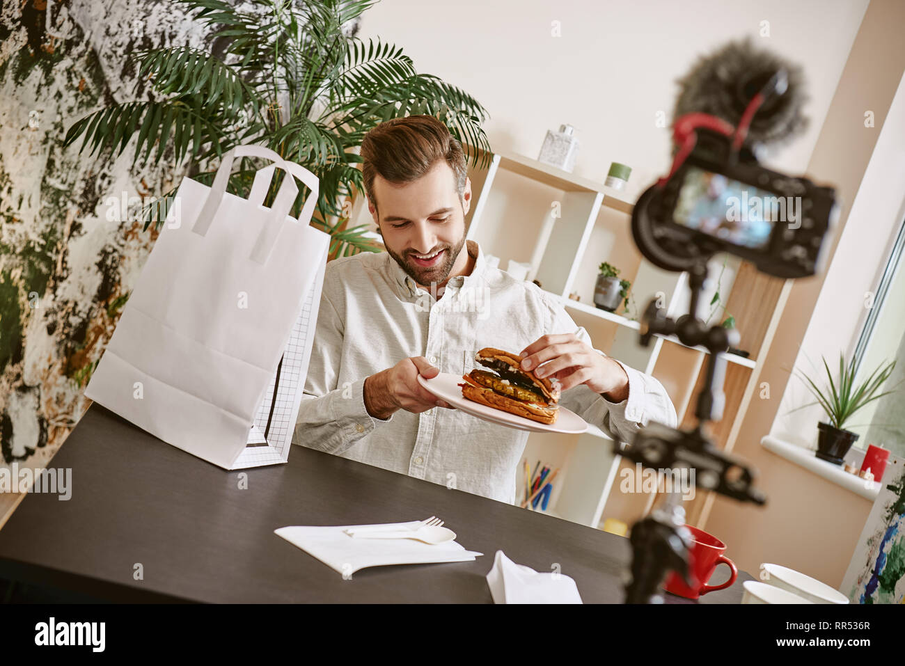 Una sana prima colazione. Positivo blogger alimentare tenendo una piastra con sandwich freschi durante la registrazione di un nuovo video per il suo vlog. Concetto di cibo. Gastronomia Foto Stock