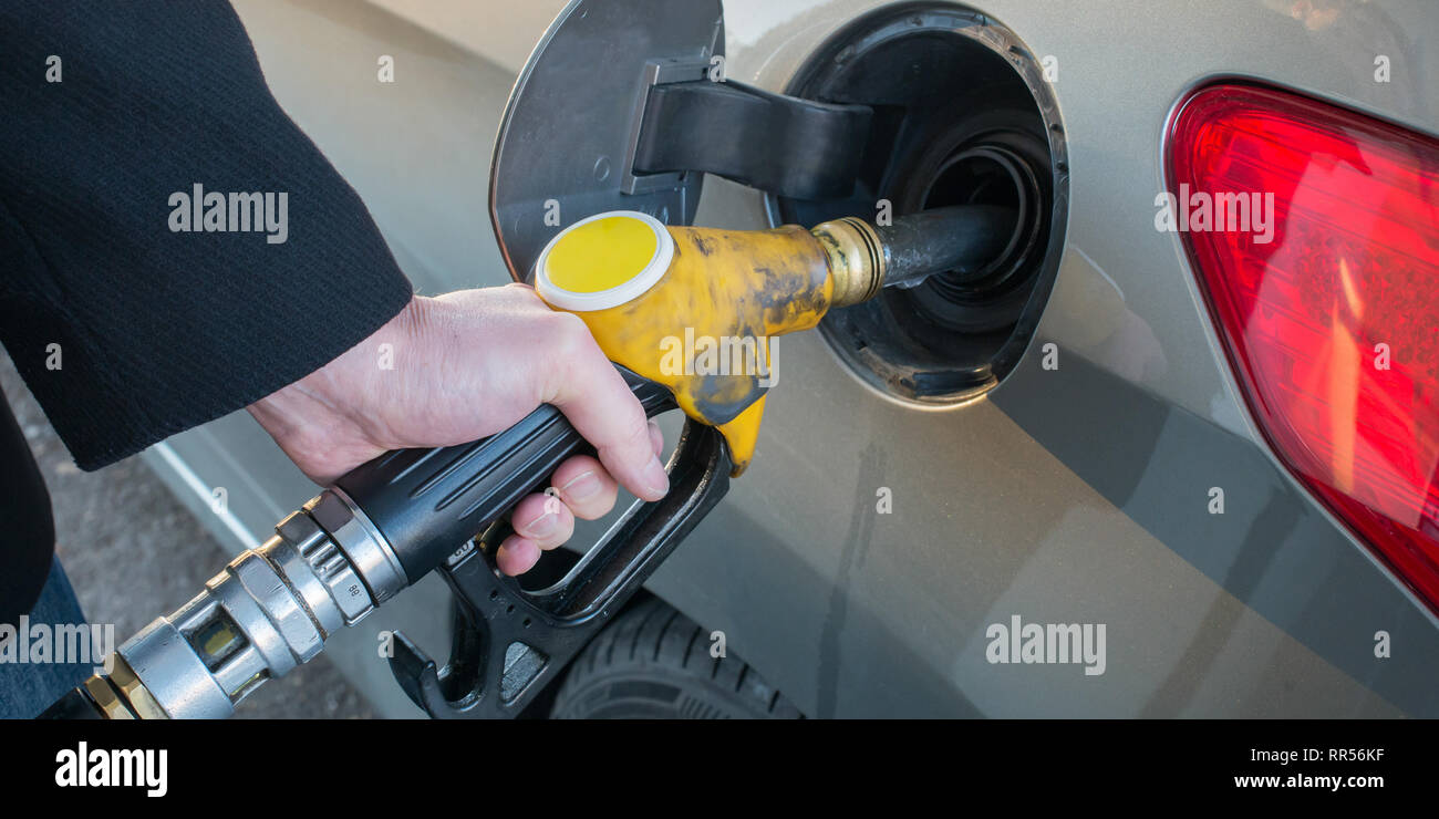 Il pompaggio del gas. Close up uomo pompando il carburante in auto alla stazione di gas. Foto Stock