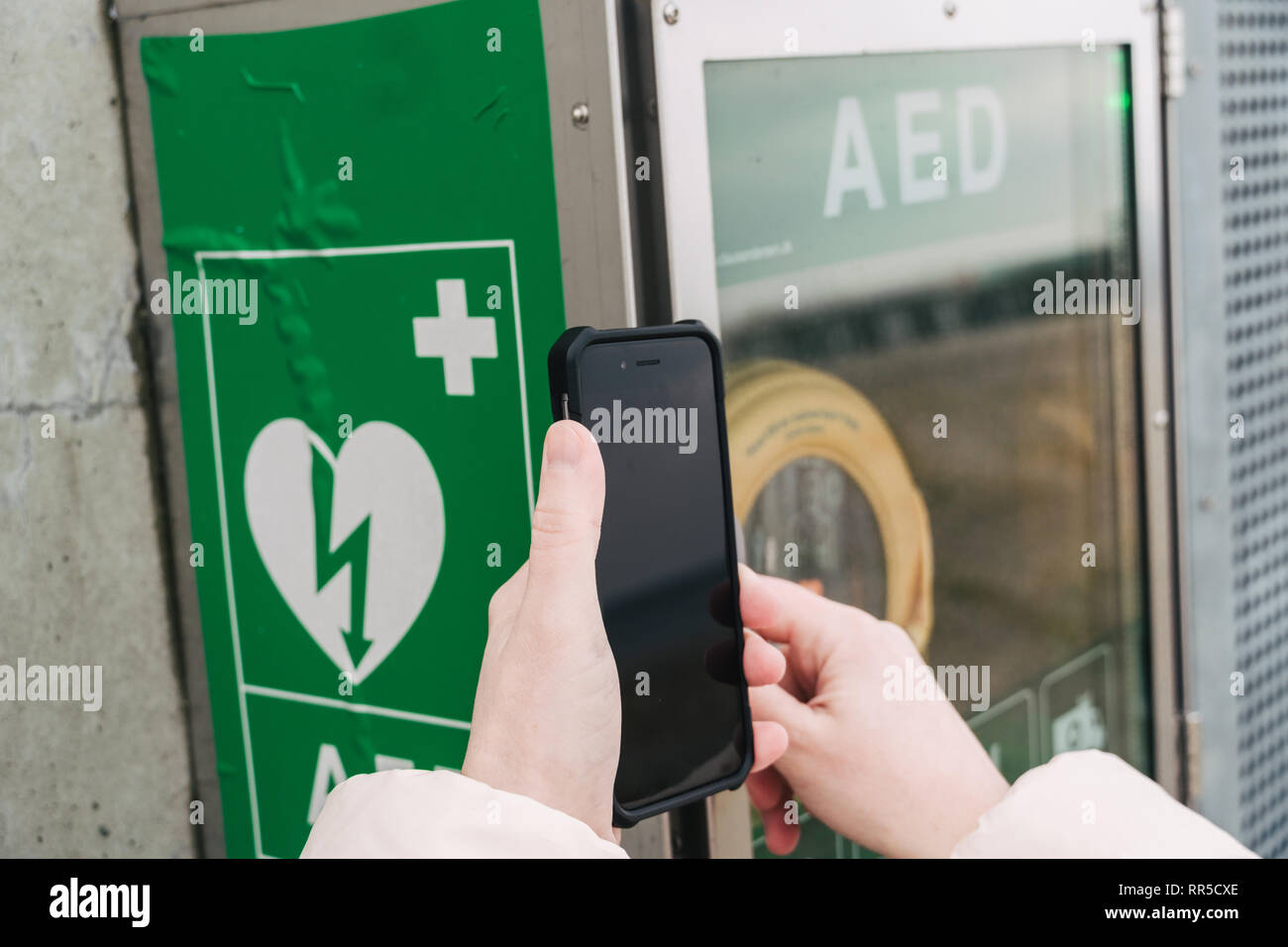 Medicina rianimazione cardiopolmonare chiamata di emergenza. La donna caucasica utilizza telefono chiamando 911 aiuto. il riquadro del dispositivo aed defibrillatore automatico malattia Foto Stock