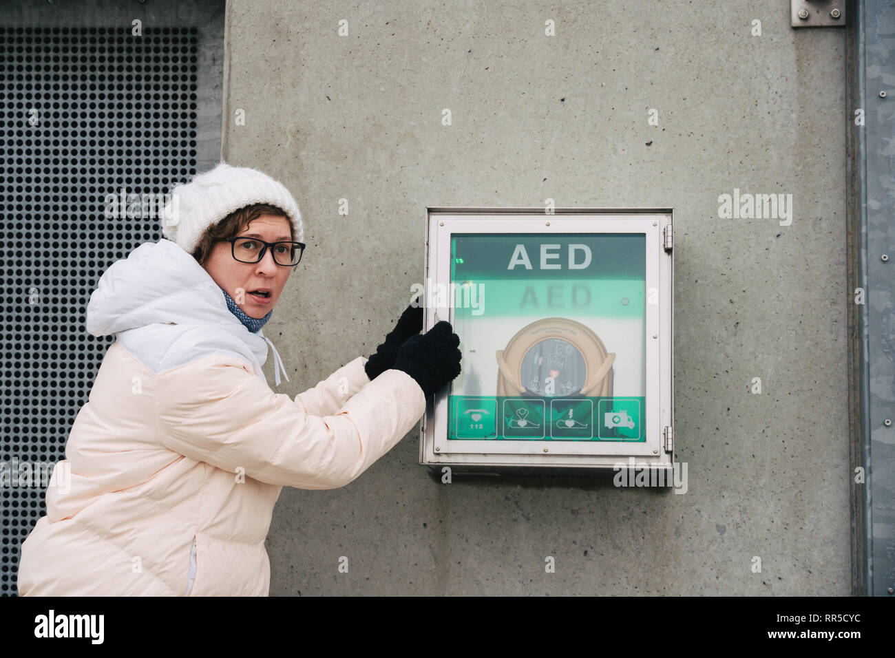 Medicina di rianimazione cardiopolmonare e di chiamata di emergenza. Giovane donna caucasica chiedendo aiuto. il riquadro del dispositivo aed defibrillatore automatico per malattie, Foto Stock