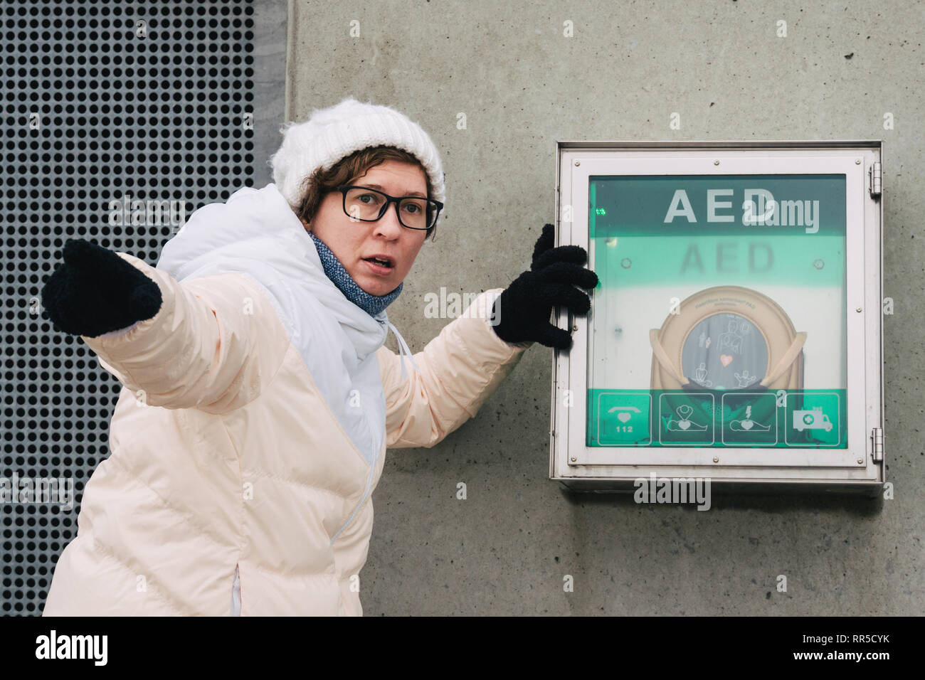 Medicina di rianimazione cardiopolmonare e di chiamata di emergenza. Giovane donna caucasica chiedendo aiuto. il riquadro del dispositivo aed defibrillatore automatico per malattie, Foto Stock