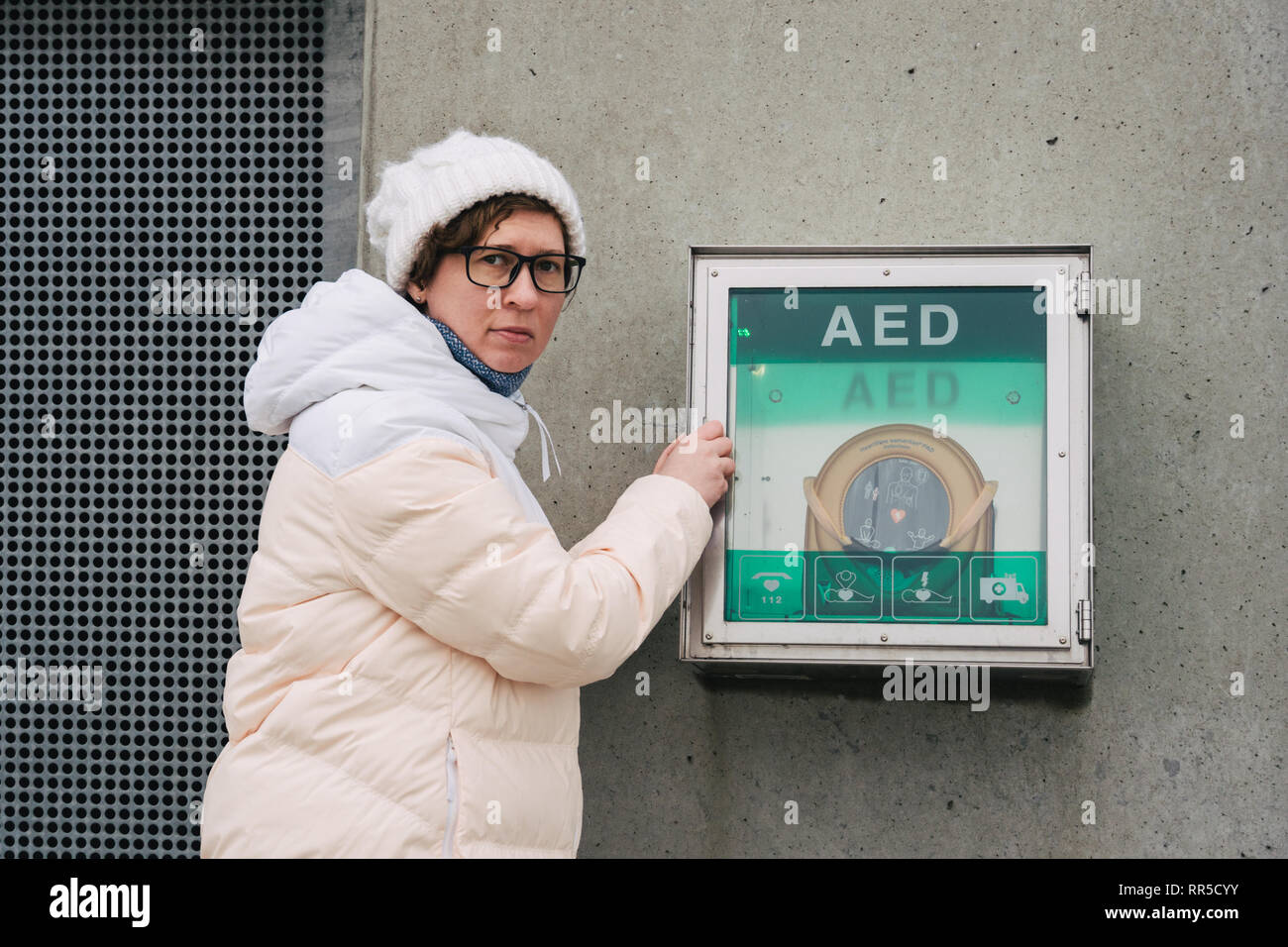 Medicina di rianimazione cardiopolmonare e di chiamata di emergenza. Giovane donna caucasica chiedendo aiuto. il riquadro del dispositivo aed defibrillatore automatico per malattie, Foto Stock