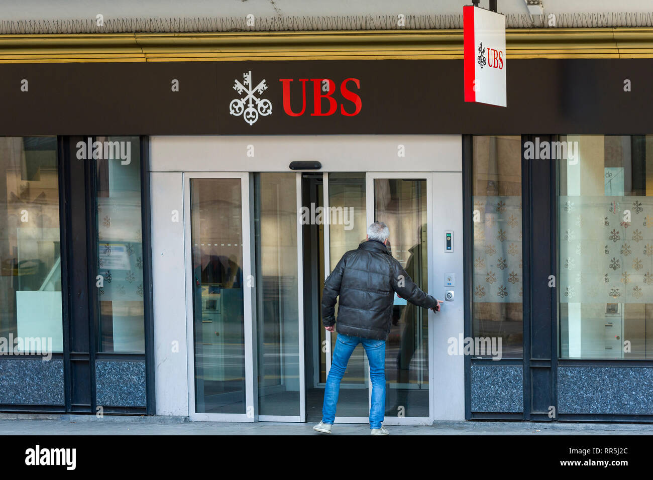 Ginevra, Svizzera - 23 Febbraio 2019: l'uomo entra in una filiale locale di UBS (Union Bank Svizzera) a Ginevra, Svizzera Foto Stock