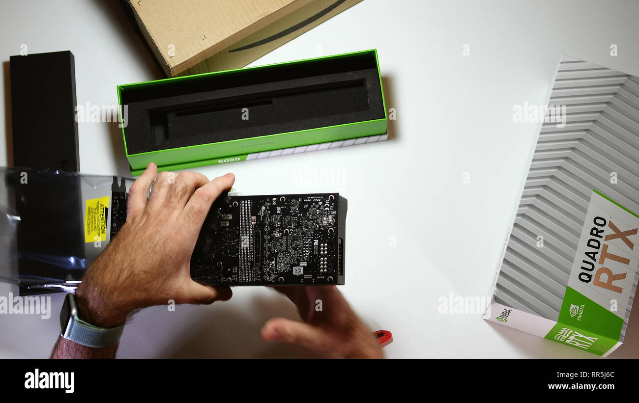 Parigi, Francia - 20 Feb 2019: vista da sopra POV uomo unboxing ultime Nvidia Quadro di RTX 5000 professional workstation scheda video GPU ammirando la grande lastra Foto Stock