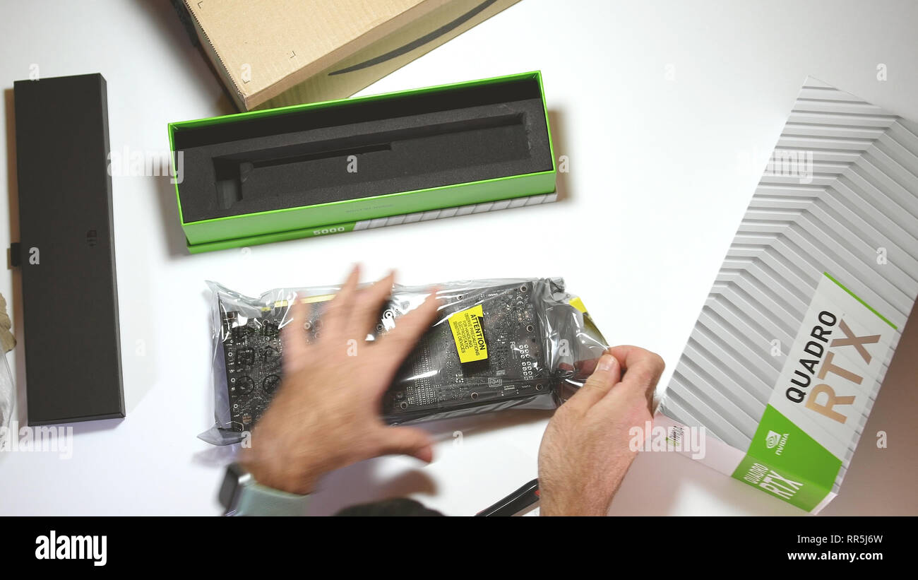 Parigi, Francia - 20 Feb 2019: vista da sopra POV uomo unboxing ultime Nvidia Quadro di RTX 5000 professional workstation scheda video GPU la rimozione dalla confezione in plastica confezione Foto Stock