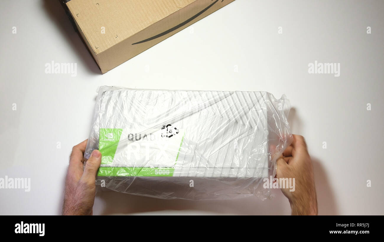 Parigi, Francia - 20 Feb 2019: vista da sopra POV uomo unboxing ultime Nvidia Quadro di RTX 5000 professional workstation scheda video GPU per CGI CAD calcoli scientifici - rimozione dalla pellicola di materia plastica Foto Stock
