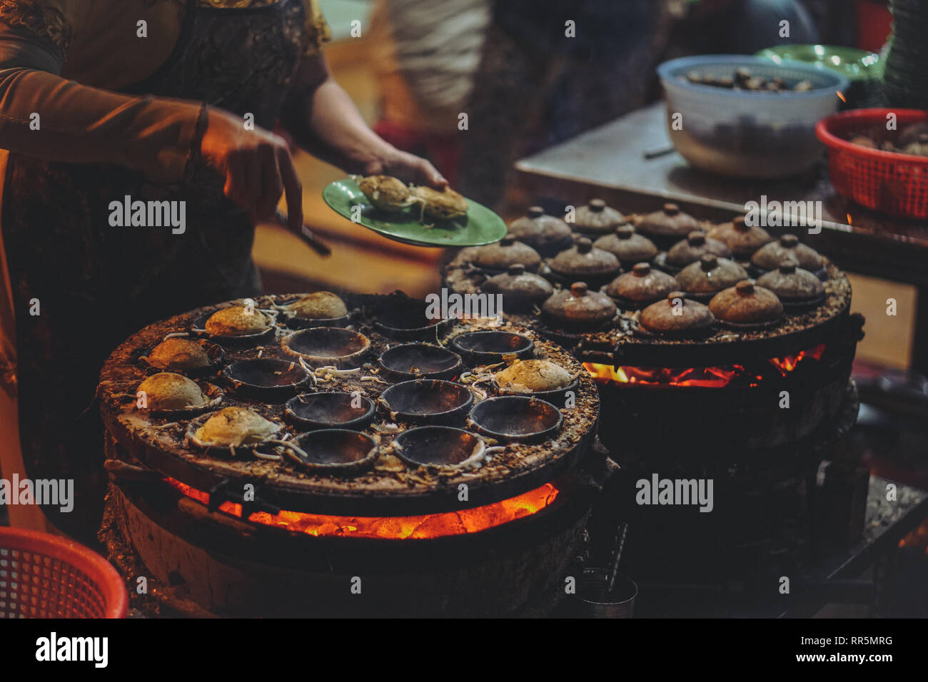 Vietnamita di cibo di strada nella notte - Banh può sulla calda ember cucina stufa Foto Stock