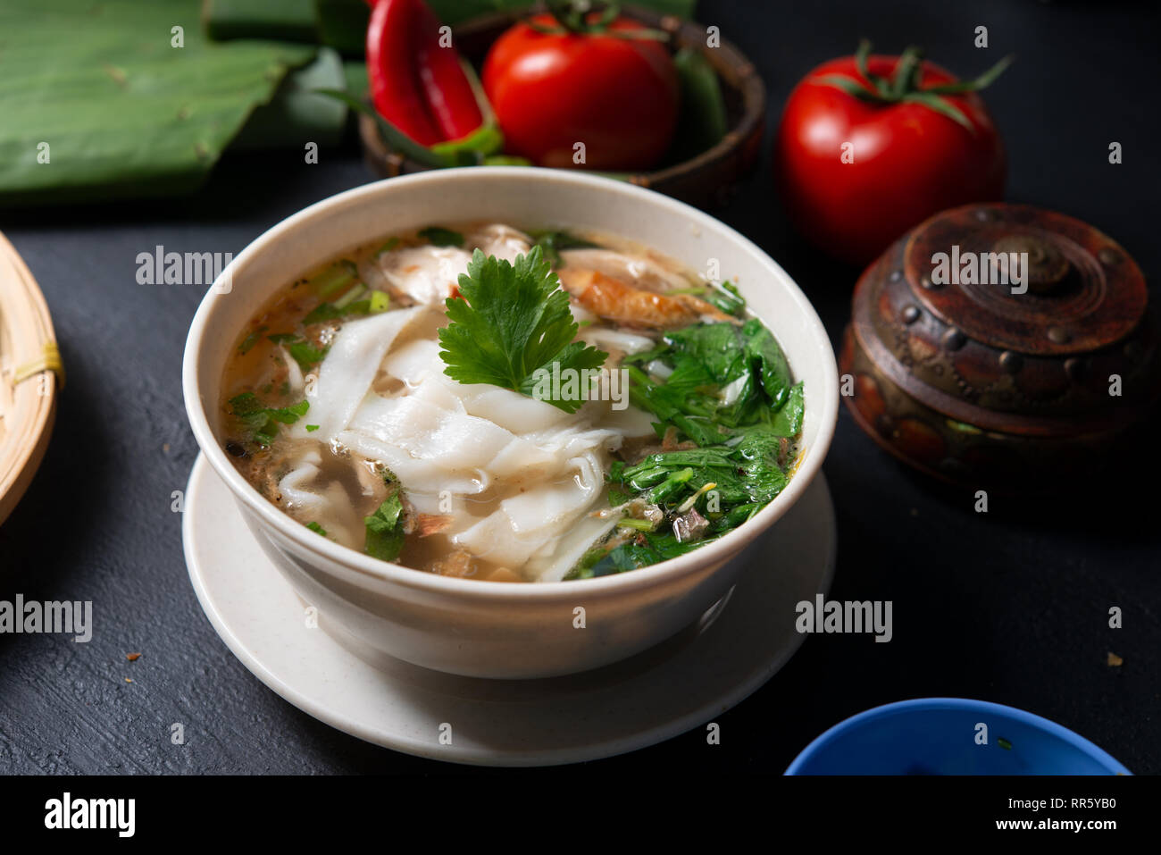 Asian kway teow zuppa di noodle al pollo e nella ciotola su sfondo scuro. Foto Stock