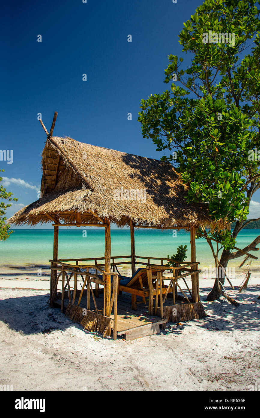 A Paradise Island Beach ombra hut e lettini per prendere il sole su una spiaggia di sabbia bianca con un bellissimo mare turchese. Foto Stock