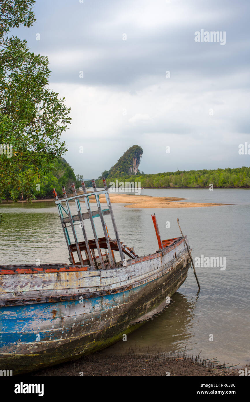 Una spiaggiata marciume imbarcazione in legno nella parte anteriore dei famosi punti di riferimento di Krabi, Thailandia. Foto Stock